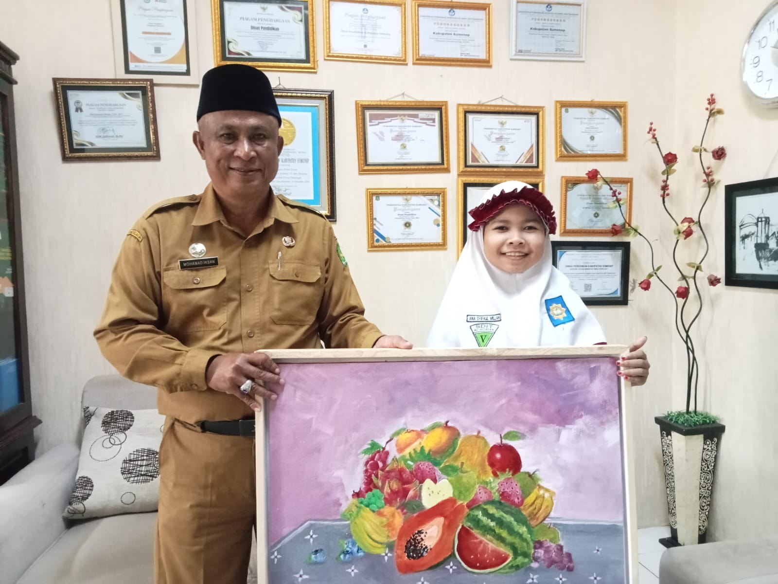 Pose Bersama Kadisdik Mohamad Iksan dengan Pelukis Cilik Sumenep dan Lukisan Buah Karya Syifaul Millah Arsa
