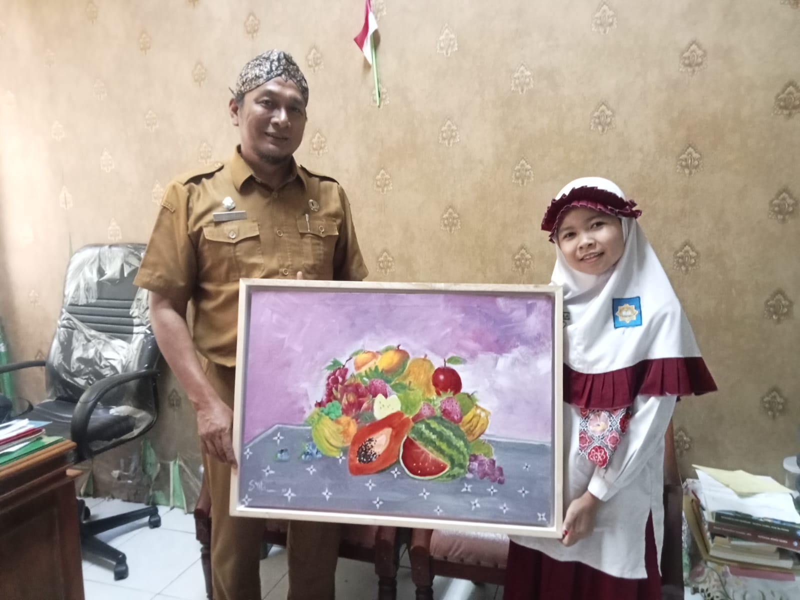 Pelukis Cilik Sumenep Syifa Foto Bersama Lukisan Buah dengan Kabid SD Disdik Sumenep, Ardiansyah Ali Shochibi, ST (Foto: Doc.dimadura)