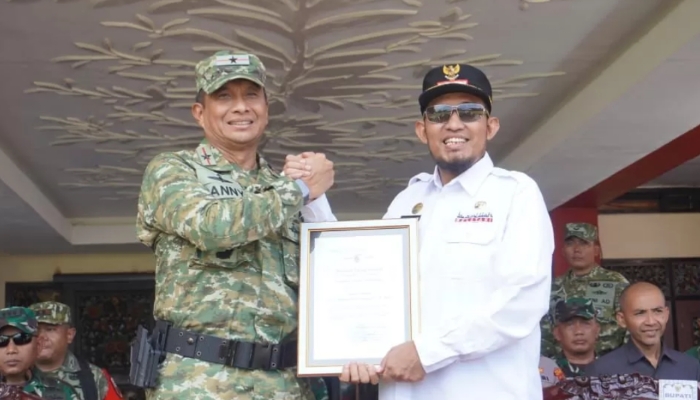 SIMBOLIS. Bupati Sumenep Achmad Fauzi Wongsojudo menerima dokumen hasil program TMMD ke-127 dari Danrem 084/Bhaskara Jaya Danny Alkadrie saat upacara penutupan di halaman Kantor Pemkab Sumenep. (foto:ist/doc.dimadura)