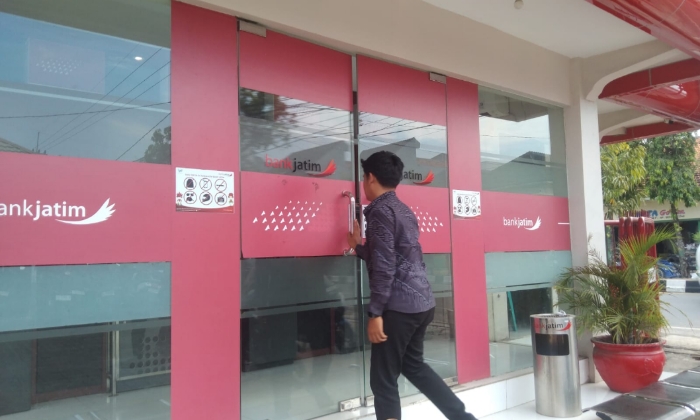 Seorang pria membuka pintu ruang ATM Bank Jatim Cabang Sumenep